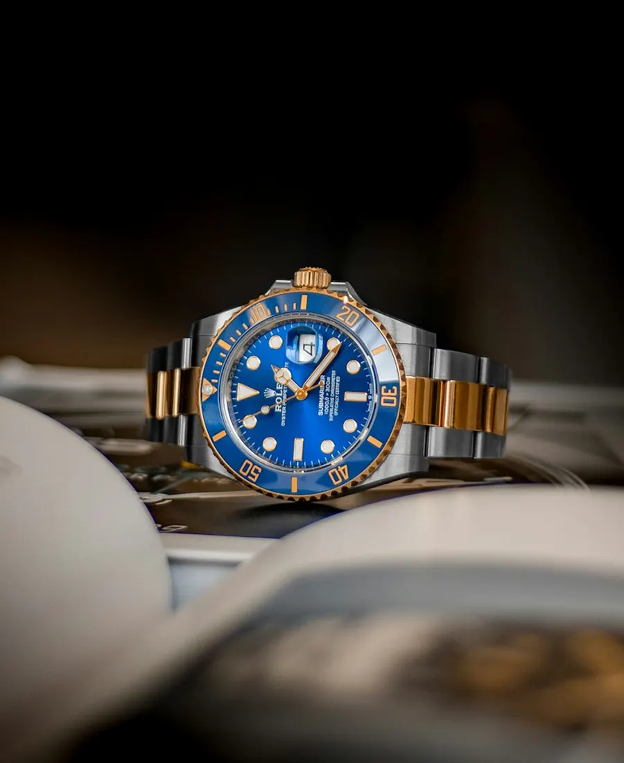 Two-tone diver's watch resting on an open book